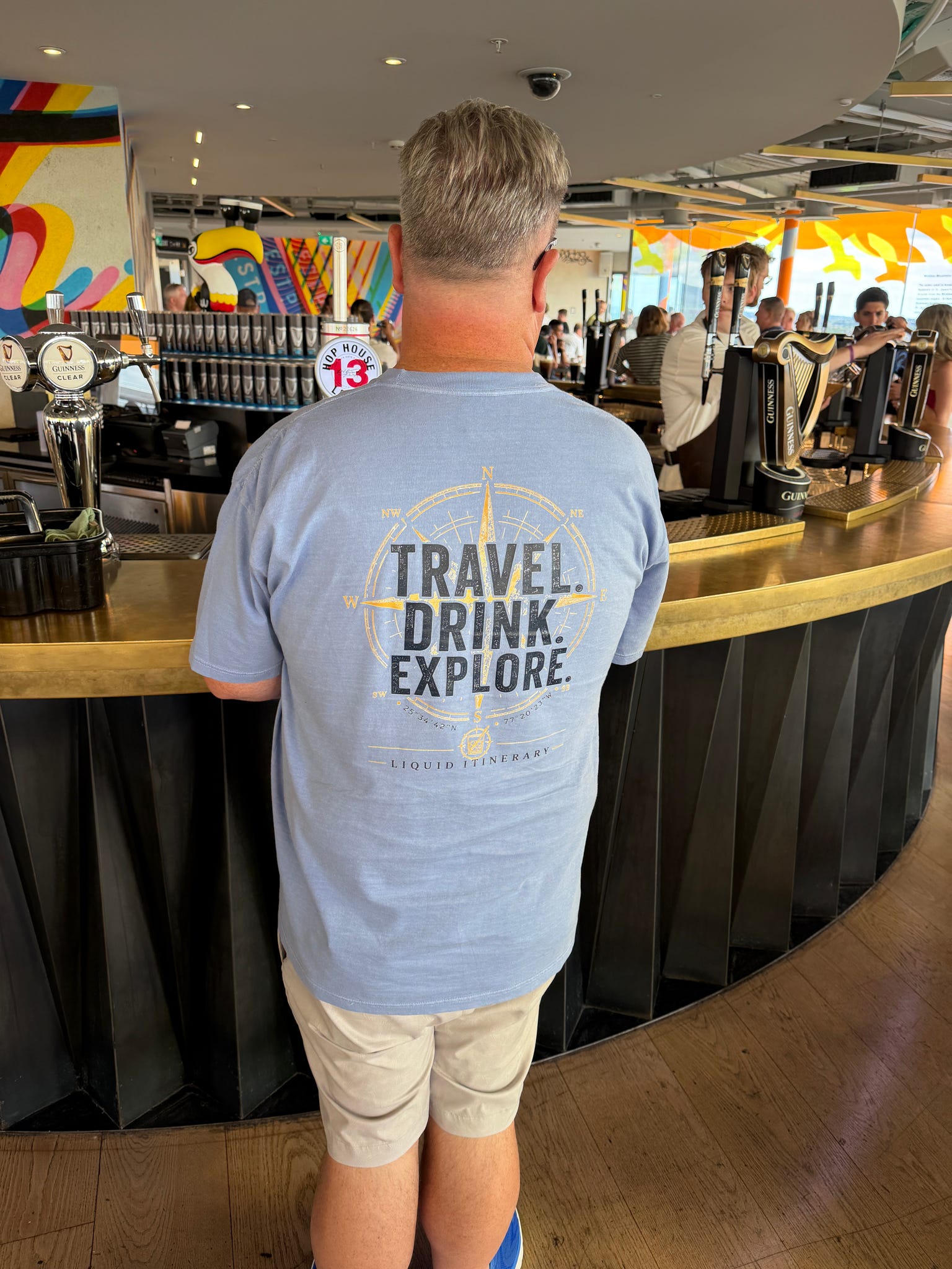 Rusty wearing the Travel. Drink. Explore. shirt at the Guinness bar in Dublin.